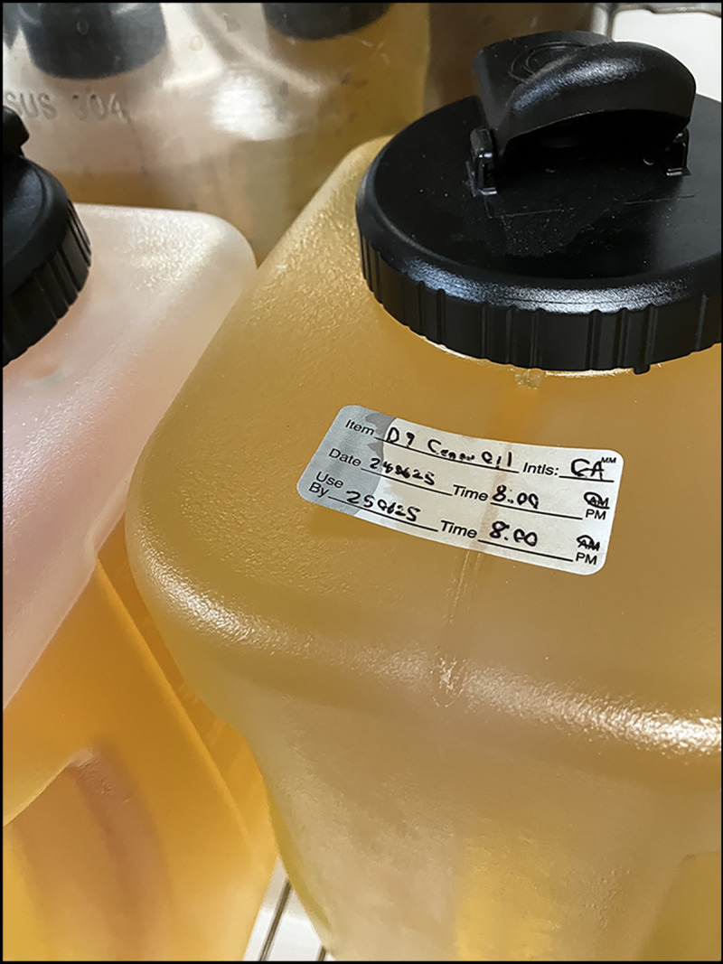 The figure is a photograph of containers with hemp-derived Δ9-tetrahydrocannabinol-infused cooking oil located in the same area as oil used to prepare pizza and bread dough in Wisconsin during October 2024.