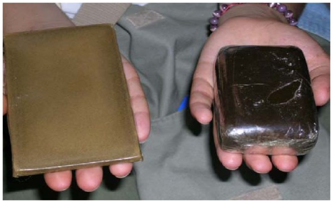 Example of compressed cannabis resin (Hashish) confiscated by Moroccan customs.Left hand: heated block of Hashish. Right hand: unheated block of Hashish.