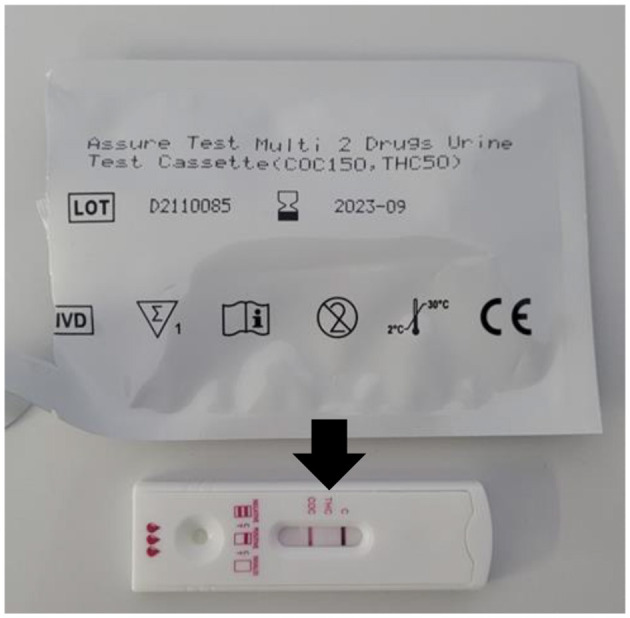 Close-up photograph of a chromatographic rapid test (plastic cassette) used to detect THC metabolites in urine. The rectangular white cassette displays two horizontal windows: a control line and a test line. A visible test line indicates a positive result, and a black arrow is placed beside the window to highlight the positive THC indication. The cassette is positioned in front of its corresponding packaging, labeled “PocT COC/THC – Assure Tech,” with additional manufacturer information visible. The layout resembles a standard lateral-flow diagnostic device used in veterinary emergency settings.