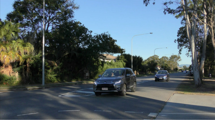 Still image from a video clip used in the Gap Acceptance Test showing a stream of oncoming traffic from the perspective of a driver waiting to turn left (i.e., looking through the side window)